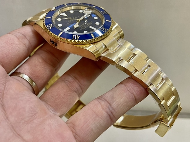 top-tier watch Rolex men's blue dial gold band blue Submariner automatic movement watch side view
