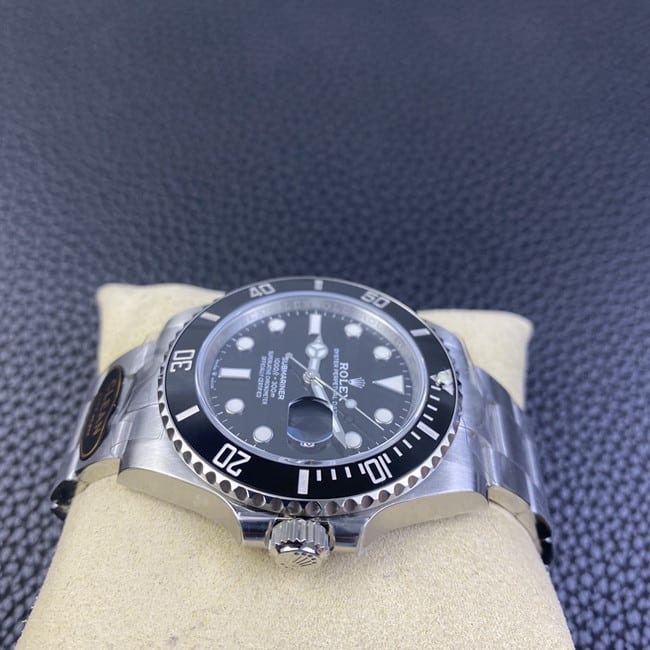 Clean factory top Rolex men's watch, black dial, steel strap, black Submariner, automatic movement, side view.
